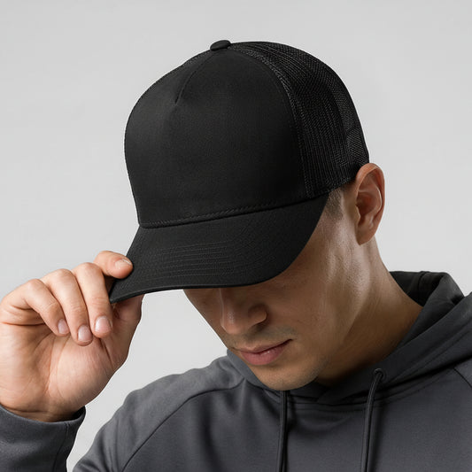 Person wearing a black cap with a logo on a gray background