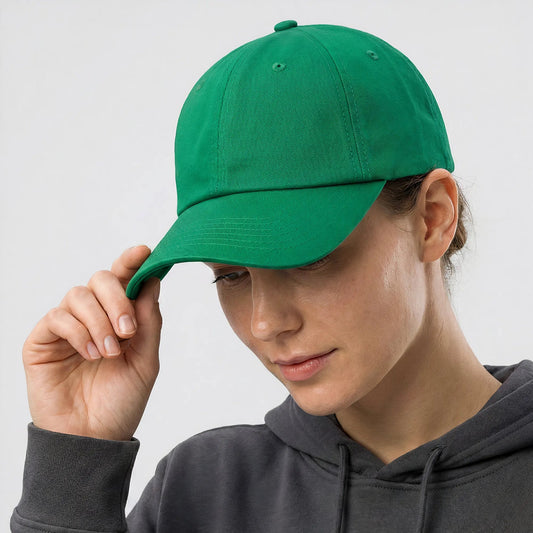 Person wearing a green cap and gray hoodie against a white background