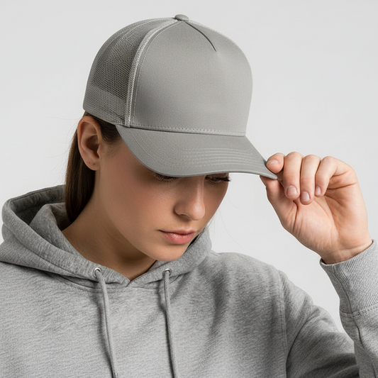 Person wearing a gray cap and hoodie against a light gray background