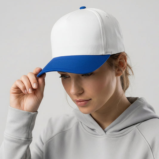 Woman wearing a white and blue cap with a logo, against a plain background