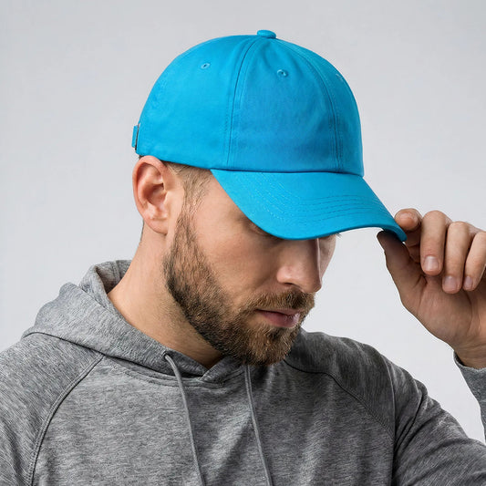 Man wearing a blue cap and gray hoodie against a light gray background