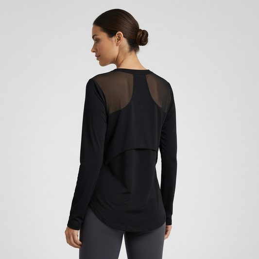 Woman wearing a black long-sleeve top with sheer mesh panels on a light gray background