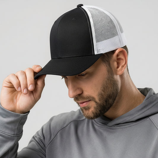 Man wearing a black and white cap with a gray hoodie on a light gray background