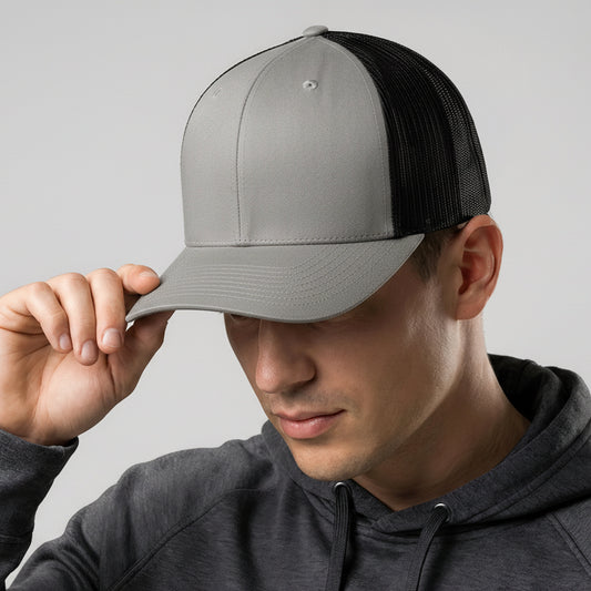 Person wearing a gray and black cap with a rainbow logo on a plain background