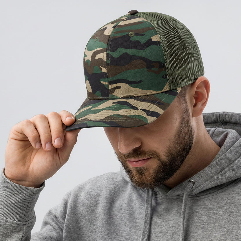 Man wearing a camouflage cap with a logo on a light gray background