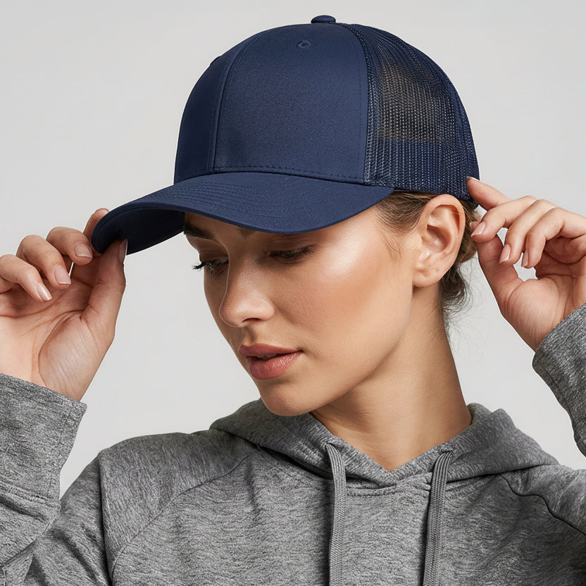 Person wearing a navy blue cap with a colorful logo on a light gray background