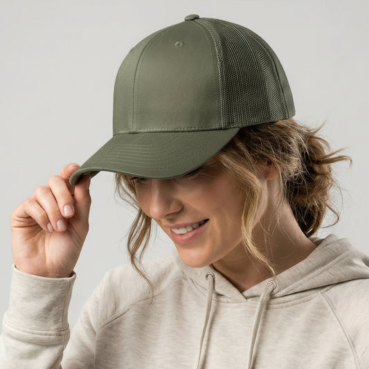 Woman wearing a green cap and beige hoodie against a plain background