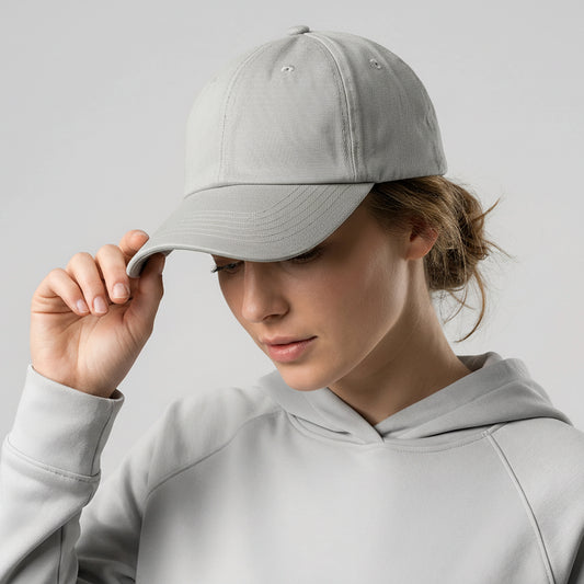 Person wearing a gray cap and hoodie against a light gray background