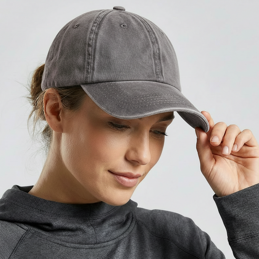 Woman wearing a gray baseball cap against a plain background