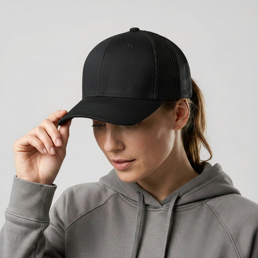 Person wearing a black cap and gray hoodie against a light background