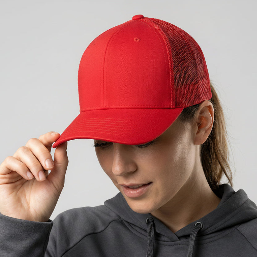 Person wearing a red cap with a logo on a gray background