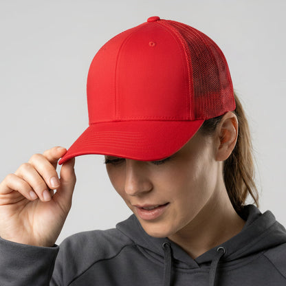 Person wearing a red cap with a logo on a gray background