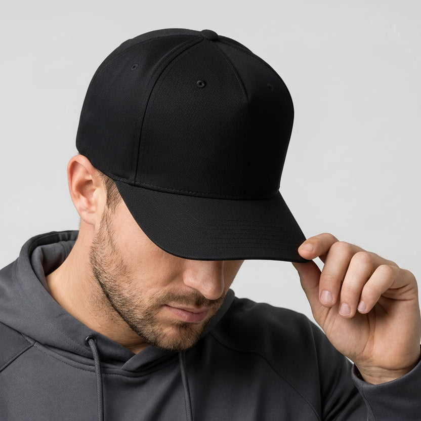 Man wearing a black cap with a rainbow logo on a gray background