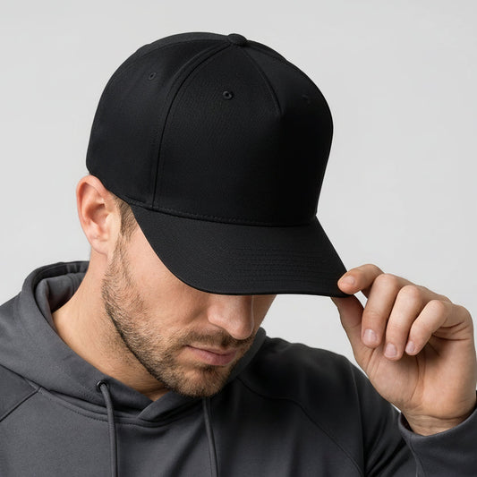 Man wearing a black cap with a rainbow logo on a gray background