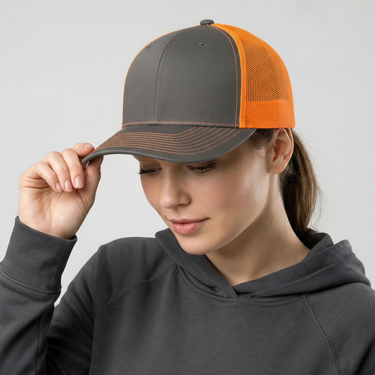 Person wearing a gray and orange cap with a logo, against a plain background