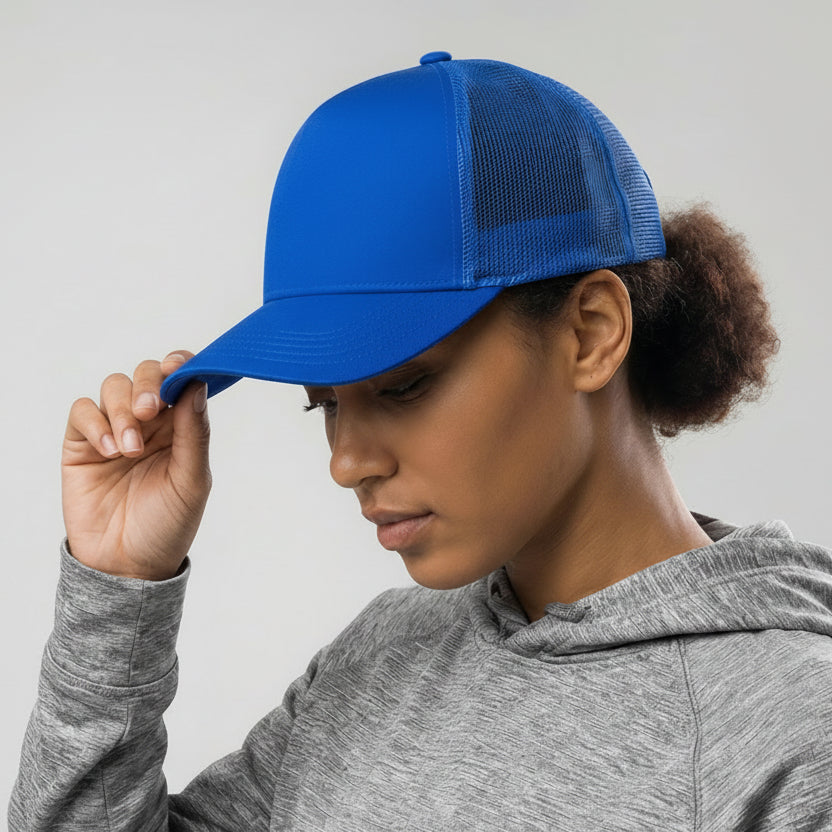 Person wearing a blue cap with a visible brand logo on a neutral background