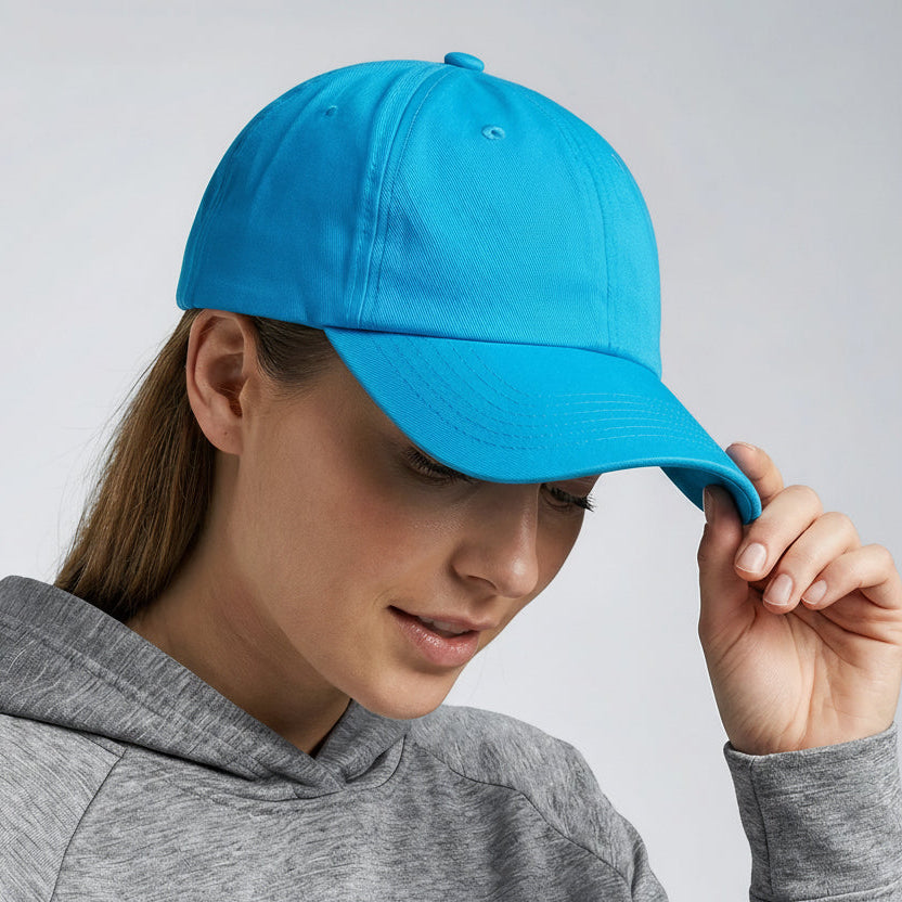 Person wearing a blue cap and gray hoodie against a light gray background