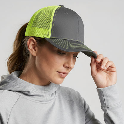 Woman wearing a gray and green cap on a plain background
