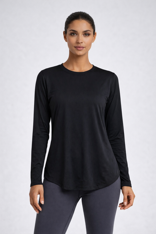 Woman wearing a black long-sleeve top and gray leggings on a white background