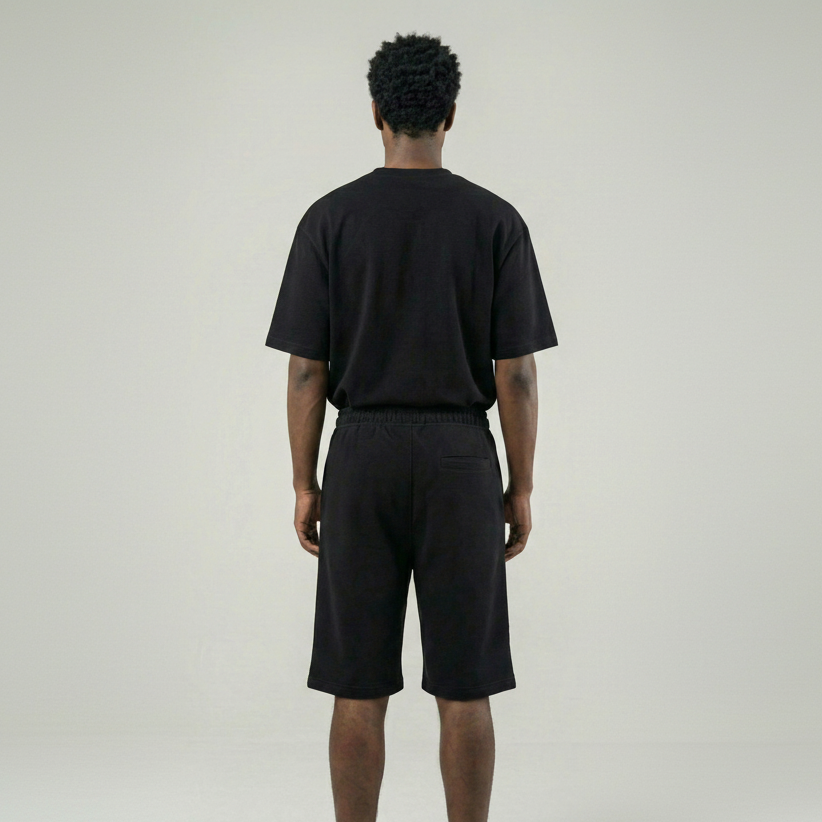 Person wearing a black t-shirt and shorts set on a plain background