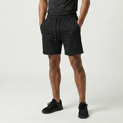 Man wearing a black t-shirt and shorts on a white background