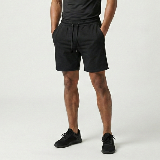 Man wearing a black t-shirt and shorts on a white background