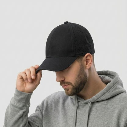 Man wearing a black cap and gray hoodie against a light gray background