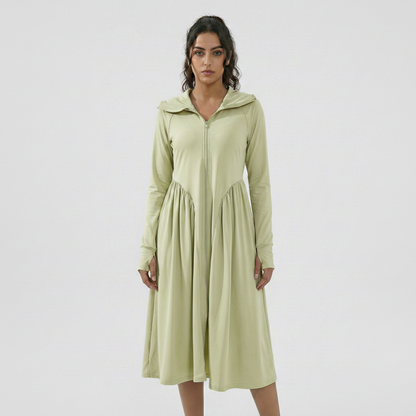 Woman wearing a light green dress with a hood on a white background