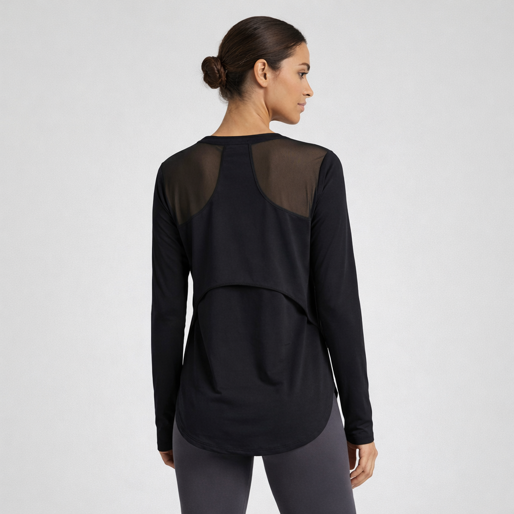 Woman wearing a black long-sleeve top with sheer mesh panels on a white background